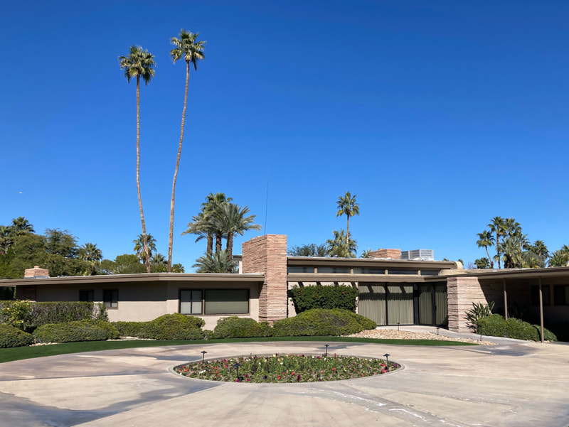 Frank Sinatra's house in Palm Springs with palm trees and blue skies